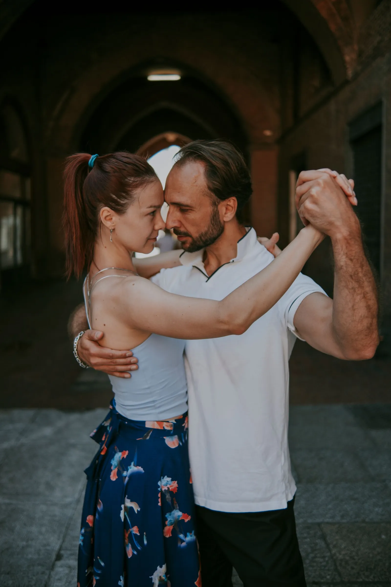 Casal a dançar a pares ao ar livre, em posição fechada