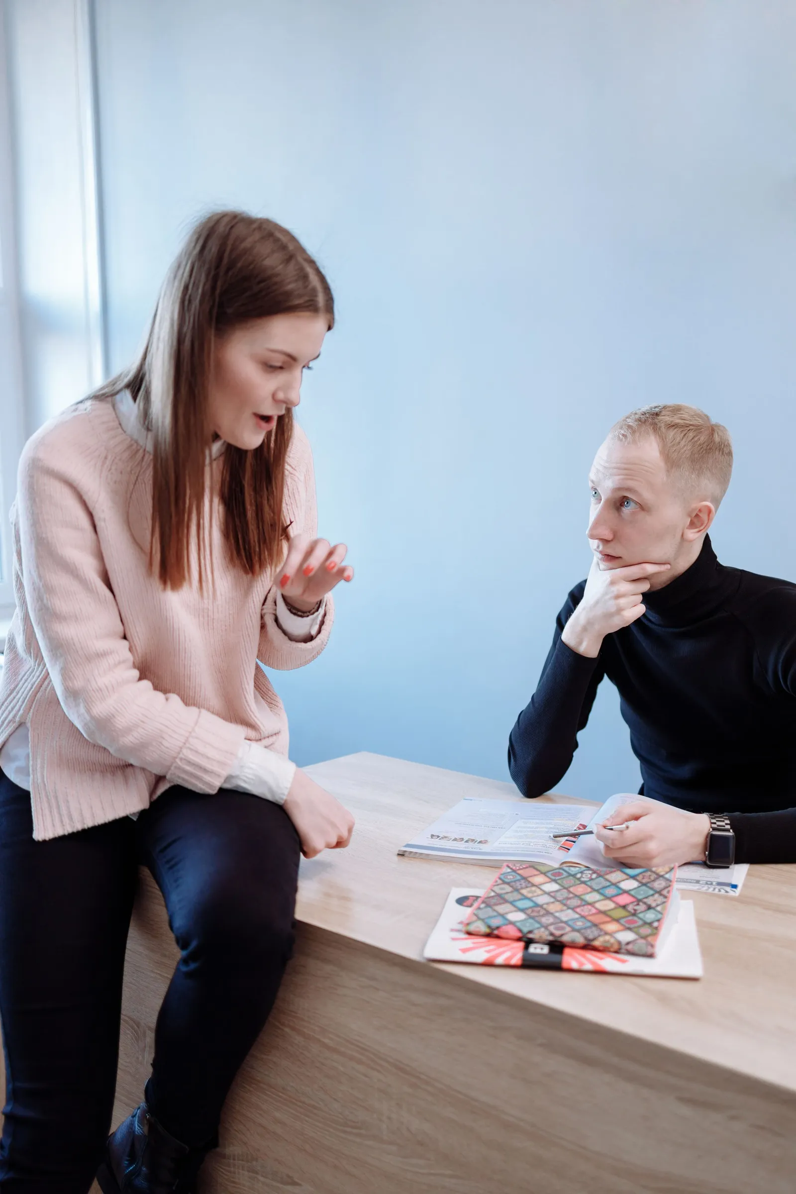Duas pessoas a estudar numa mesa com um livro